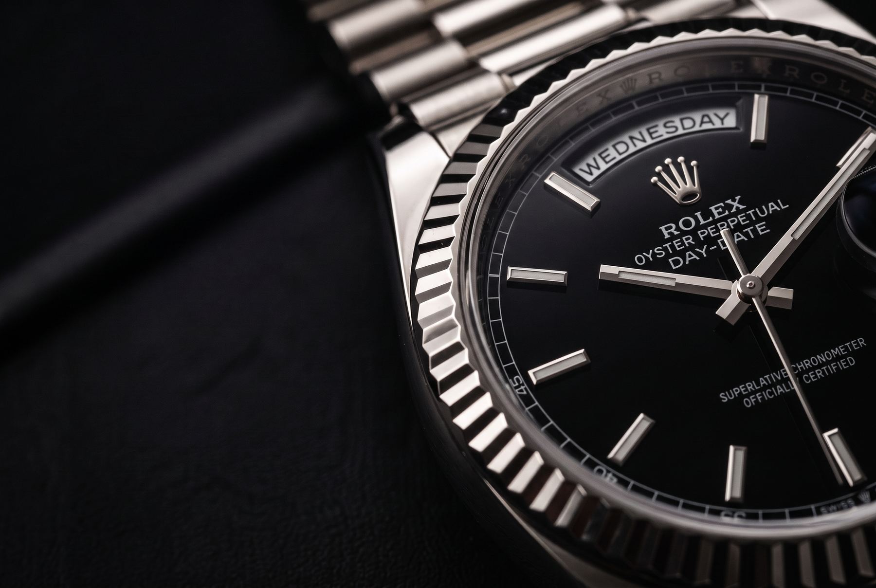 Rolex Day-Date 40 Weissgold mit schwarzem Zifferblatt auf dunklem Hintergrund